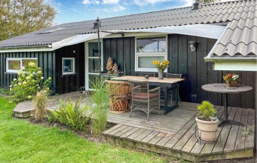 a house with a wooden deck with a table at 3 Bedroom Cozy Home In Nibe in Nibe