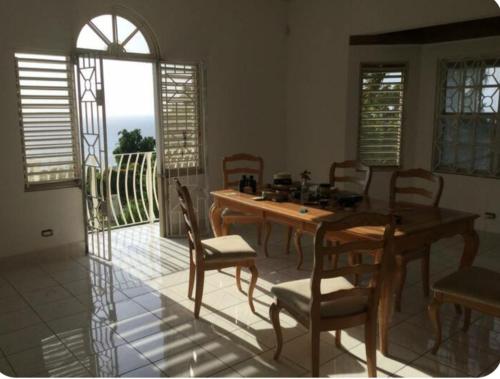 a dining room with a wooden table and chairs at Montego Bay Guesthouse in Montego Bay