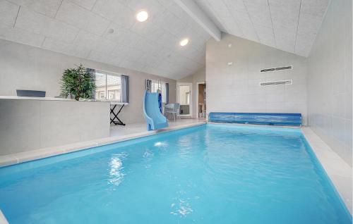 a large swimming pool with a slide in a building at Nice Home In Nørre Nebel With Sauna in Nørre Nebel