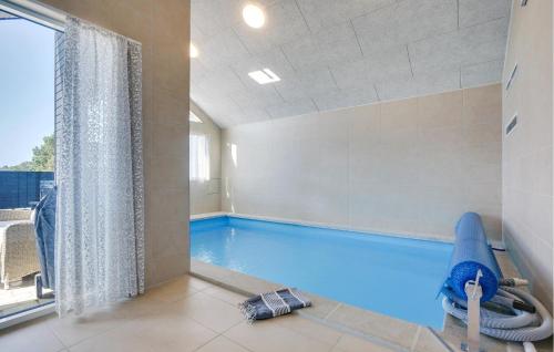 a indoor swimming pool with a pool noodle in a room at Lovely Home In Vejers Strand With Sauna in Vejers Strand