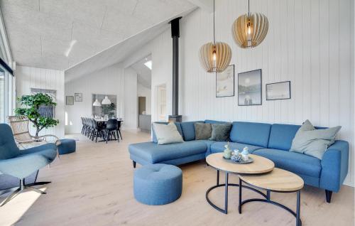 a living room with a blue couch and a table at Lovely Home In Vejers Strand With Sauna in Vejers Strand