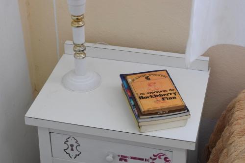 a white bedside table with a book on it at Hotel Che Mar in Necochea