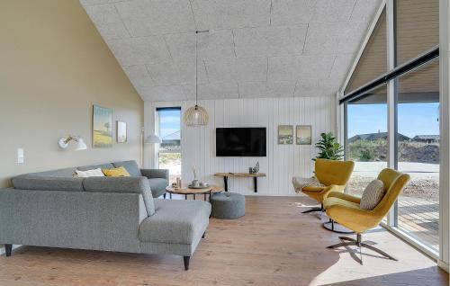a living room with a couch and chairs and a tv at Amazing Home In Hvide Sande With Sauna in Bjerregård
