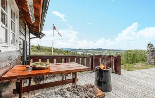 a wooden table on a deck with a fire pit at 4 Bedroom Stunning Home In Hemsedal in Hemsedal