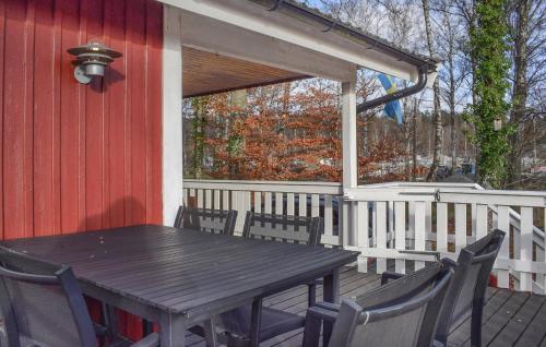 a wooden table and chairs on a deck at Lovely Home In Backaryd With Lake View in Backaryd