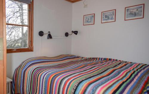 a bedroom with a colorful striped blanket on a bed at Lovely Home In Backaryd With Lake View in Backaryd