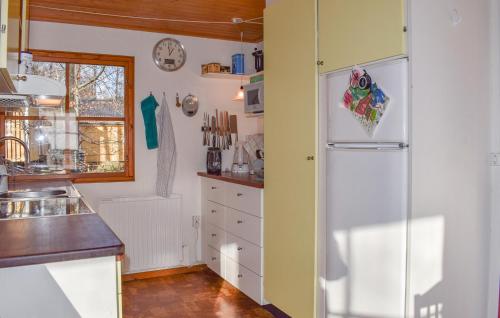 a kitchen with white cabinets and a refrigerator at Lovely Home In Backaryd With Lake View in Backaryd