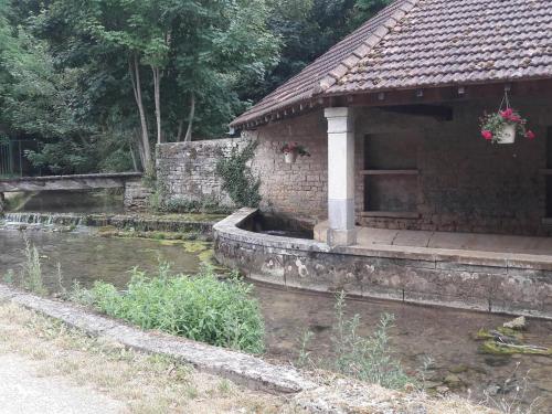 a stone building with a pond in front of it at Chambres de caractère avec parc fermé et stationnement sécurisé - FR-1-583-278 in Choye
