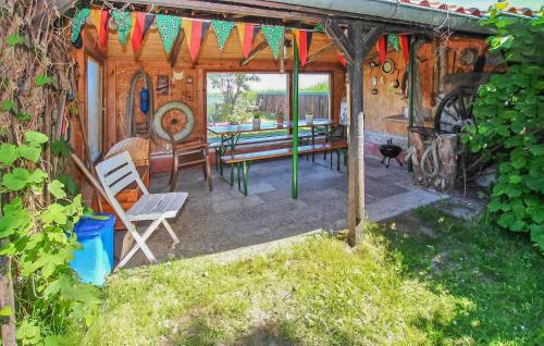 einem Holzschuppen mit einem Picknicktisch und einer Bank in der Unterkunft Ferienhaus Ueckermünde Bellin in Bellin
