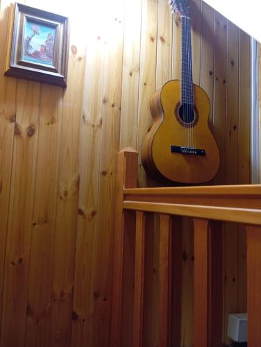 a guitar is hanging on the wall of a room at Casa Umberna in Asiago
