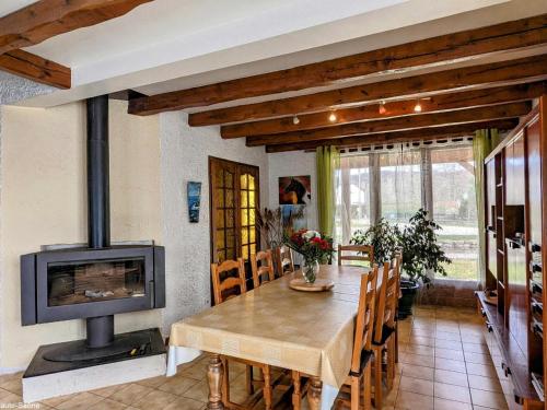 une salle à manger avec une table et une cheminée dans l'établissement Maison charmante avec jardin, terrasse et parking près du Ballon d'Alsace - FR-1-583-297, à Plancher-Bas