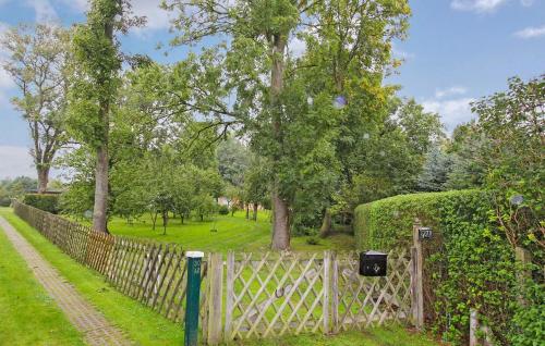 una recinzione in un parco con alberi e erba di Ferienhaus Bartelshagen Ii a Bartelshagen