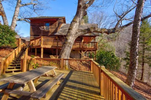 a tree house with a bench on a deck at Fox's Lair in Sugar Grove
