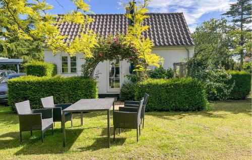 a table and chairs in front of a house at Strandhytten in Allinge