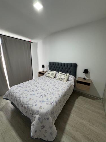 ein Schlafzimmer mit einem großen Bett mit blauem Kopfteil in der Unterkunft Amaneceres patagónico in Puerto Madryn