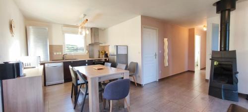 a kitchen with a wooden table and a stove at Maison plain-pied Calme et Nature in Cuvier