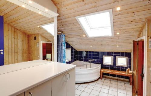 a bathroom with a large tub and a sink at Four-Bedroom Holiday Home In Allinge in Allinge