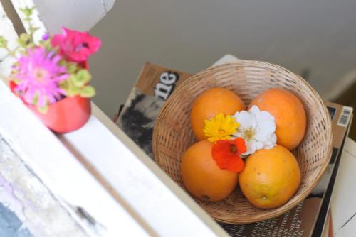 a basket of oranges with flowers in a vase at Hotel Che Mar in Necochea