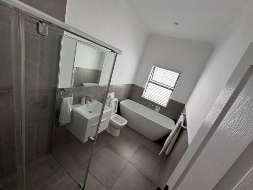 een badkamer met een toilet, een wastafel en een douche bij Tinchley Havanna, Luxury 3 Bedroom home in Kaapstad