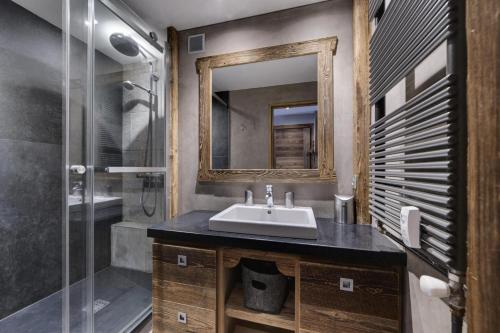 une salle de bain avec un lavabo, une douche et un miroir dans l'établissement Résidence Pramecou - Appartement rénové · Au pied des pistes · MAE-4421, à Tignes