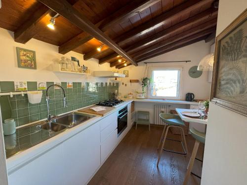 a kitchen with white cabinets and a sink and a table at Pantheon Gabbianina Home in Rome