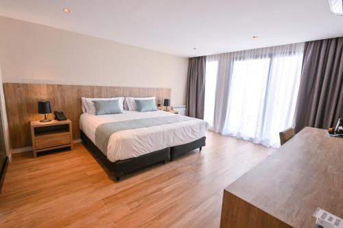 a bedroom with a large bed and wooden floors at Hotel Denver Mar del Plata in Mar del Plata