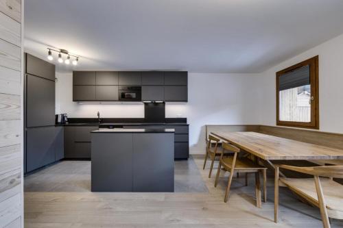 Il comprend une cuisine et une salle à manger avec une table en bois. dans l'établissement Résidence Maison Neuve - Appartement rénové·Pied des pistes·Balcon·Parking MAE-0391, à Tignes