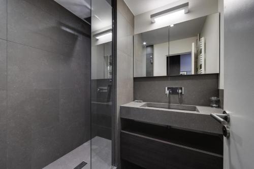 une salle de bain avec un lavabo et une douche avec un miroir dans l'établissement Résidence Hauts Du Val Claret B2 - Appartement renové·Pied des pistes·Balcon MAE-3641, à Tignes