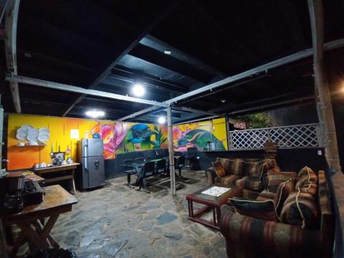 a living room with couches and a painting on the wall at Hostal Las Mariposas Minca in Minca