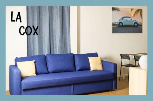 - un canapé bleu dans un salon avec une voiture bleue dans l'établissement LA COX - Studio rénové avec vue - wifi, à Chamalières