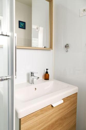 une salle de bain avec un lavabo blanc et un miroir dans l'établissement LA COX - Studio rénové avec vue - wifi, à Chamalières