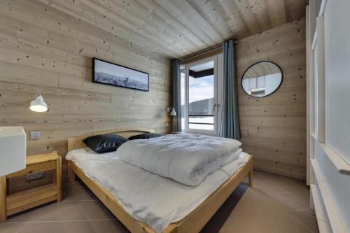 une chambre avec un lit dans un mur en bois dans l'établissement Résidence Hauts Du Val Claret B2 - Appartement renové·Pied des pistes·Balcon MAE-9001, à Tignes