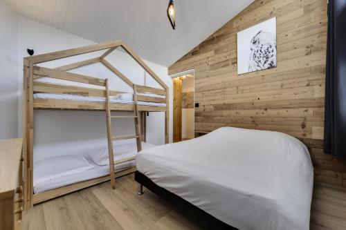 - une chambre avec des lits superposés et un mur en bois dans l'établissement Résidence Hameau De Toviere - Appartement confort et rénové · Proche des pistes MAE-8811, à Tignes