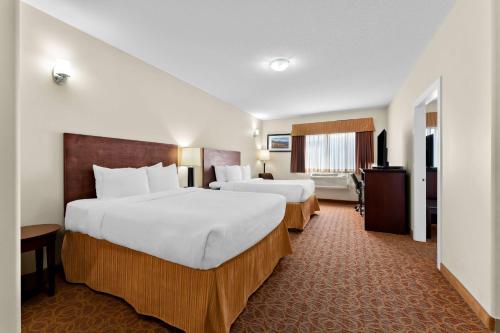 a hotel room with two beds and a television at Best Western Williams Lake in Williams Lake