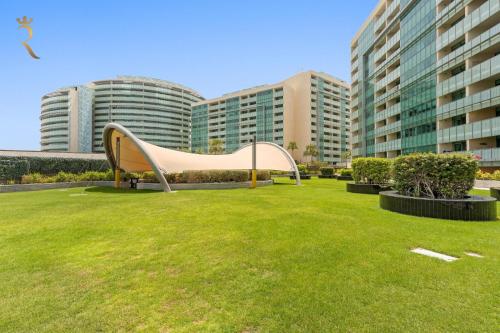 a park with a slide in front of some buildings at Luxury 2BR Living in Al Rahah - Elegant Stay Near Al Raha Beach & Marina in Abu Dhabi