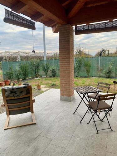 a patio with a table and chairs and a bench at Casa di Barbara in Piumazzo