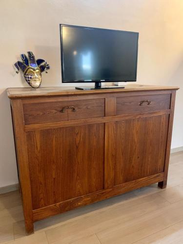a television on top of a wooden cabinet at Casa di Barbara in Piumazzo