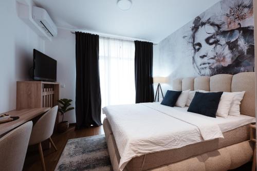 a bedroom with a bed and a desk and a television at inJoy in Belgrade