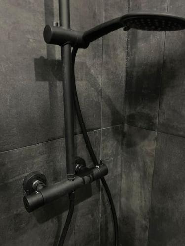 a metal piping on the wall of a shower at Studio Buttes Chaumont refait à neuf in Paris