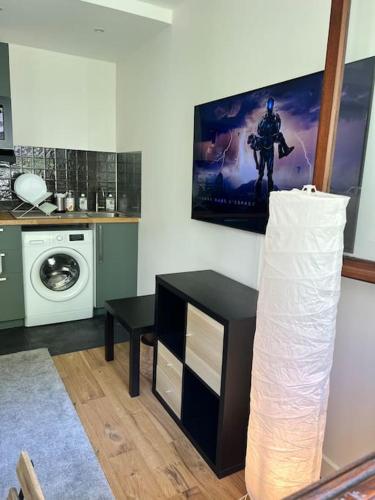 a room with a kitchen with a washing machine at Studio Buttes Chaumont refait à neuf in Paris