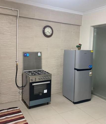 a kitchen with a stove and a refrigerator at A Cozy Apartment Near Cairo Airport in Cairo