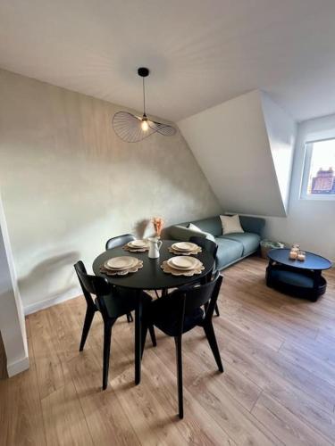 un salon avec une table et un canapé dans l'établissement L Émeraude, à Beauvais