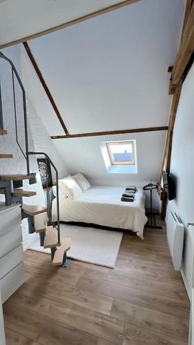 - une chambre avec un lit et des escaliers dans l'établissement L Émeraude, à Beauvais