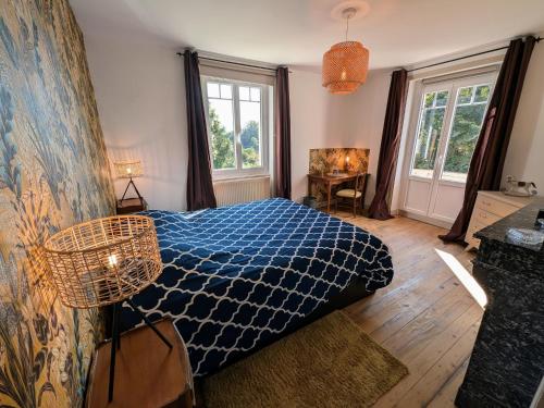 - une chambre avec un lit doté d'un couvre-lit bleu et 2 fenêtres dans l'établissement Le Domaine des Vignes - FR-1-583-366, à Chargey-lès-Gray