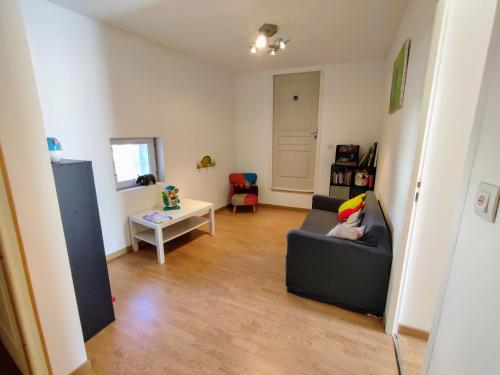 a living room with a couch and a table at Gîte confortable avec cheminée et parking, proche Verdun - FR-1-585-159 in Dompcevrin