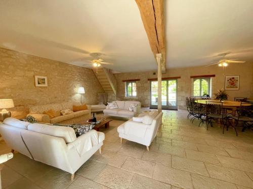 un grand salon avec des canapés blancs et une table dans l'établissement Gîte en Touraine avec piscine privée, spa et WiFi - FR-1-381-601, à Cussay