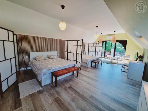 une chambre avec deux lits et un parquet dans l'établissement Gîte bien-être avec piscine, spa et sauna à Gussignies - FR-1-510-223, à Gussignies