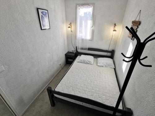 une petite chambre avec un lit et une fenêtre dans l'établissement Résidence Le Carlton - 2 Pièces 4 couchages PORT LEUCATE. Réf: 2CAR_128AC MAE-0911, à Leucate