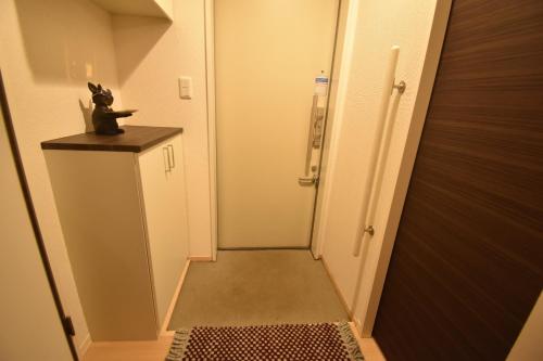 a hallway with a cat figurine sitting on top of a door at 憩いStation in Chiba