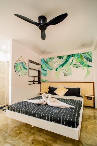 a bedroom with a bed with a ceiling fan at HayyaHayya Villas in Ocoy